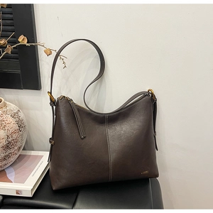 Detailed view of dark brown hobo bag featuring contrast white stitching and leather texture