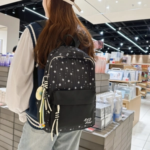Detail of black star pattern backpack with RKD BAG logo and colorful pendant accessories