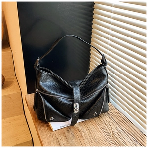 Detail of black pebbled leather tote featuring silver zippers and metallic buckle accents