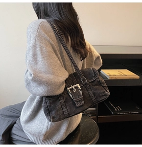 Détail du sac Boston en jean vintage avec grande boucle en métal argenté sur tissu