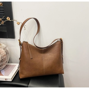 Close-up of brown leather tote bag with elegant stitching and brand logo detailing