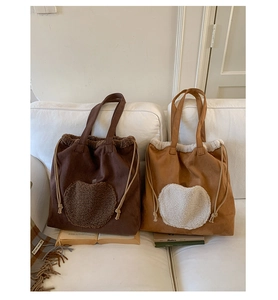 Detail of vintage large tote bags featuring heart plush patches and drawstring closure