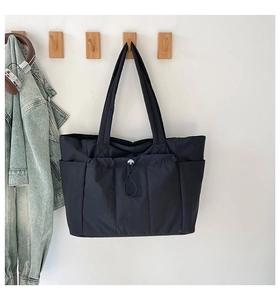 Détail du sac fourre-tout noir en nylon avec plusieurs poches et tissu imperméable et cordon