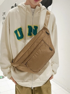 Sac bandoulière en nylon à carreaux kaki de grande capacité porté sur un sweat beige