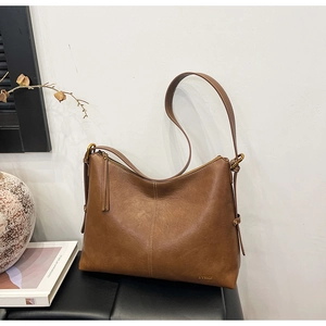 Detail showing high-quality vintage brown leather texture and logo on large tote bag
