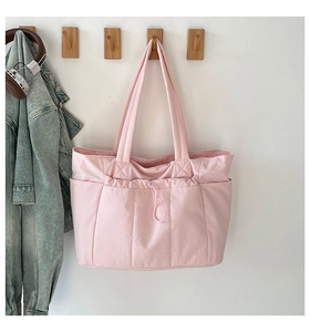 Vue détaillée du sac cabas rose tendre avec poche à cordon et large bandoulière