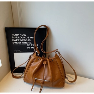 Gros plan du sac seau matelassé marron caramel en similicuir avec cordon de serrage