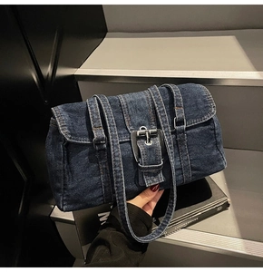Détail du sac d'épaule en denim bleu foncé avec boucles argentées et sangles de style vintage