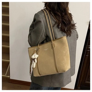 Detail of khaki tote bag with plush bear charm and Fashion & Bags leather logo print