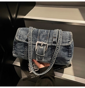 Détail du sac Boston en denim vintage avec texture délavée et boucle en métal argenté