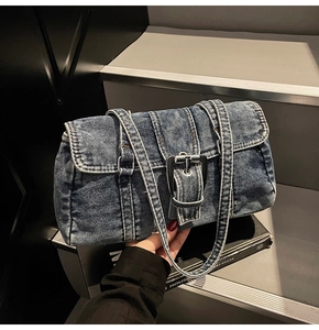 Détail du sac Boston en denim rétro avec surpiqûres blanches et boucle en métal