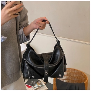 Detail of black pebbled leather hobo bag with silver zippers and buckle strap