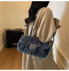 Détail du sac bandoulière vintage en denim délavé bleu marine avec boucle en métal argenté