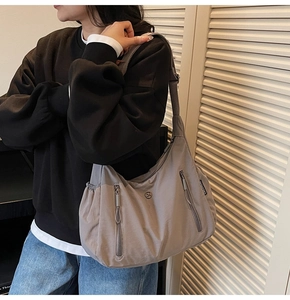 Détail du sac bandoulière gris en nylon imperméable avec plusieurs poches zippées