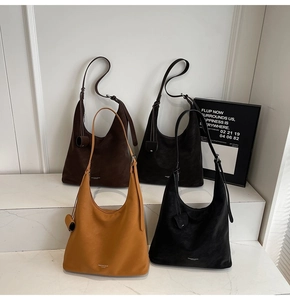 Detail of high-capacity suede tote bags in four colors on marble display