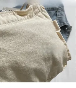 Detailed macro view of beige canvas texture and stitching on casual crossbody bag