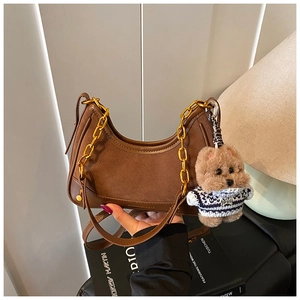 Brown suede hobo bag with gold chain strap and a cute teddy bear charm detail