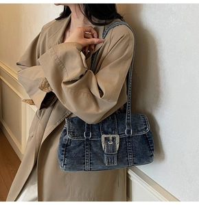 Gros plan sur un sac à bandoulière vintage en jean bleu porté par un mannequin