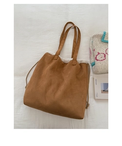 Flat lay of brown suede tote bag with white fleece trim and long shoulder straps