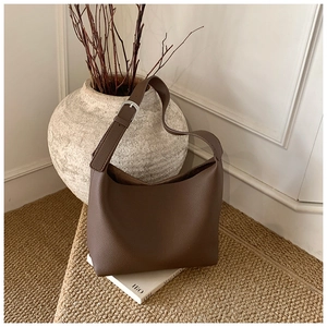 Detail view of dark brown lychee pattern leather and silver buckle on hobo bag