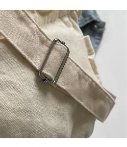 Macro shot of durable beige canvas strap with adjustable silver metal buckle detail