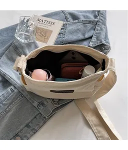 Macro view showing the large interior capacity of this beige canvas tote bag with daily items
