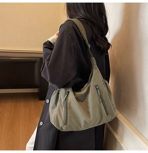 Détail du sac hobo en nylon vert olive avec zips frontaux et bandoulière réglable