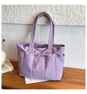 Détail du sac cabas matelassé violet avec poche frontale à cordon et doubles bandoulières