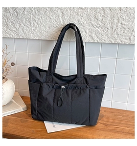 Détail du sac cabas en nylon noir avec poche à cordon et texture matelassée