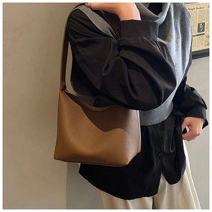Brown litchi grain leather hobo bag worn on shoulder for stylish daily commute