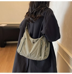 Détail du sac hobo en nylon vert clair avec poches zippées et bandoulière ajustable