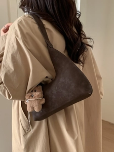 Bolso tote de ante marrón oscuro a la moda con forma de media luna y un colgante de oso