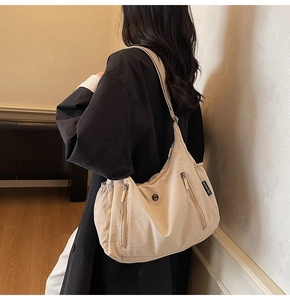 Détail du sac bandoulière beige en nylon imperméable avec poche latérale et étiquette