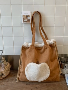 Brown faux suede tote bag with white faux shearling trim and drawstring side details