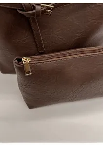 Detail of a dark brown bucket bag set featuring smooth leather texture and golden hardware