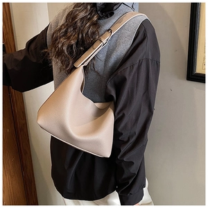 Detail of beige lychee textured leather hobo bag showing shoulder strap and premium finish