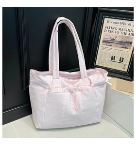 Détail du sac cabas matelassé rose en nylon avec fermeture à cordon et texture douce
