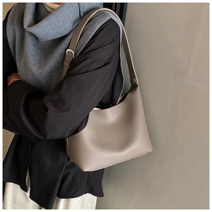 Detail of adjustable strap and lychee texture on the taupe minimalist hobo tote bag