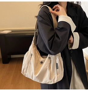 Détail du grand sac bandoulière en nylon avec poches zippées porté par un mannequin