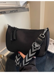 Black canvas crossbody bag with wide chevron strap and thick woven zipper puller