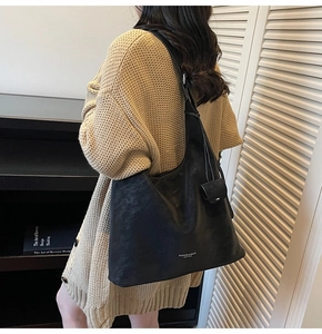 Detail view of large black leather hobo bag with mini pouch and shoulder strap