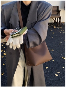 Detail of dark brown pebble leather tote bag shown with a gray blazer for autumn style