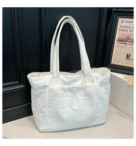Détail du sac cabas en nylon blanc avec poche à cordon et tissu froissé léger