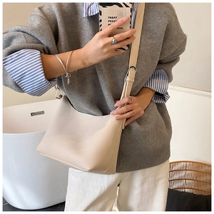 Close-up of beige lychee pattern leather tote bag with adjustable shoulder strap