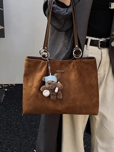Brown suede tote bag with diamond embossing and cute bear charm shown on a model