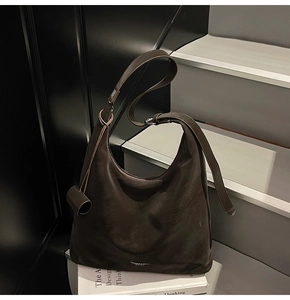 Detailed macro view of dark brown leather tote bag with subtle minimalist branding text