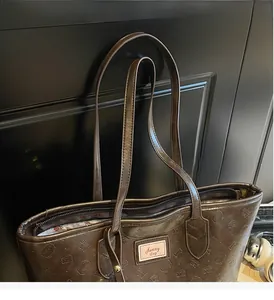 Close-up of the smooth handles and zip closure on this brown embossed bear tote bag