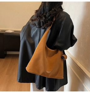 Detail of tan leather tote bag showing smooth matte texture and fashion embossed text