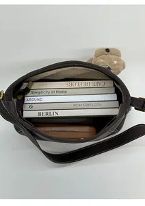 Interior view showing high capacity of dark brown bucket bag with books and phone