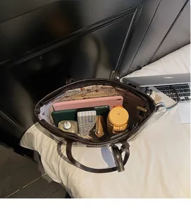 Interior detail of large brown tote bag with bear lining showing storage capacity